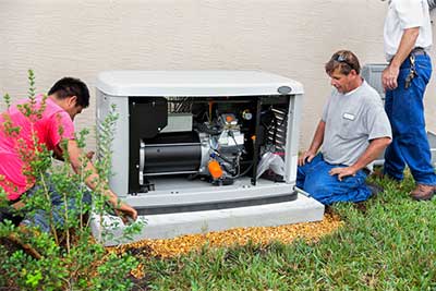 workers install a whole-building generator